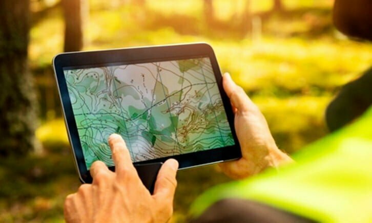 Hand points to an Ipad showing topographic map-like image