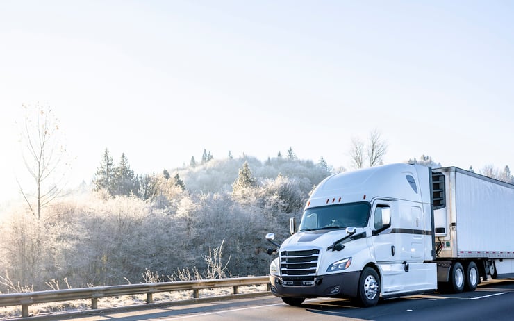 Expedited delivery truck driving on road in front of mountain