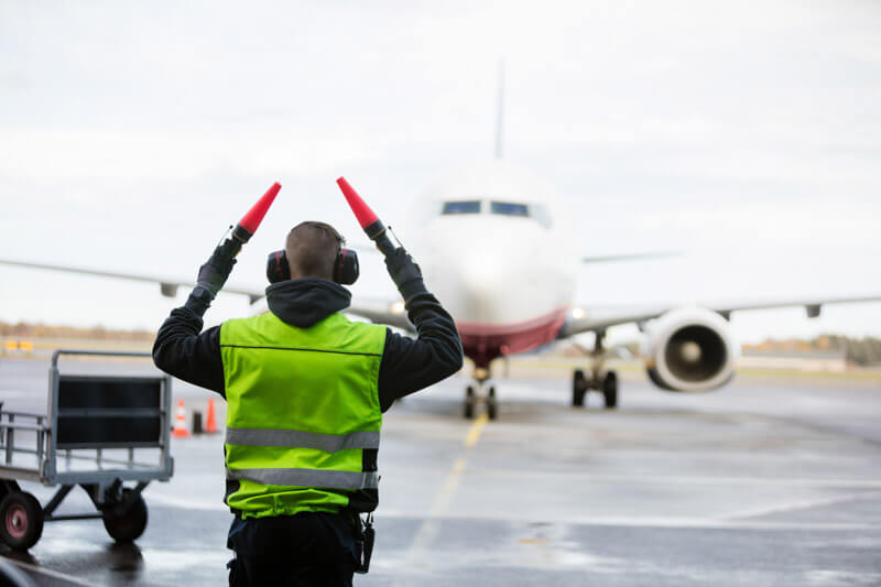 An aircraft marshal directing a jet into a gate