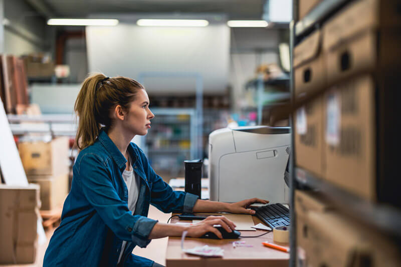 A woman working on a computer in a manufacturing facility